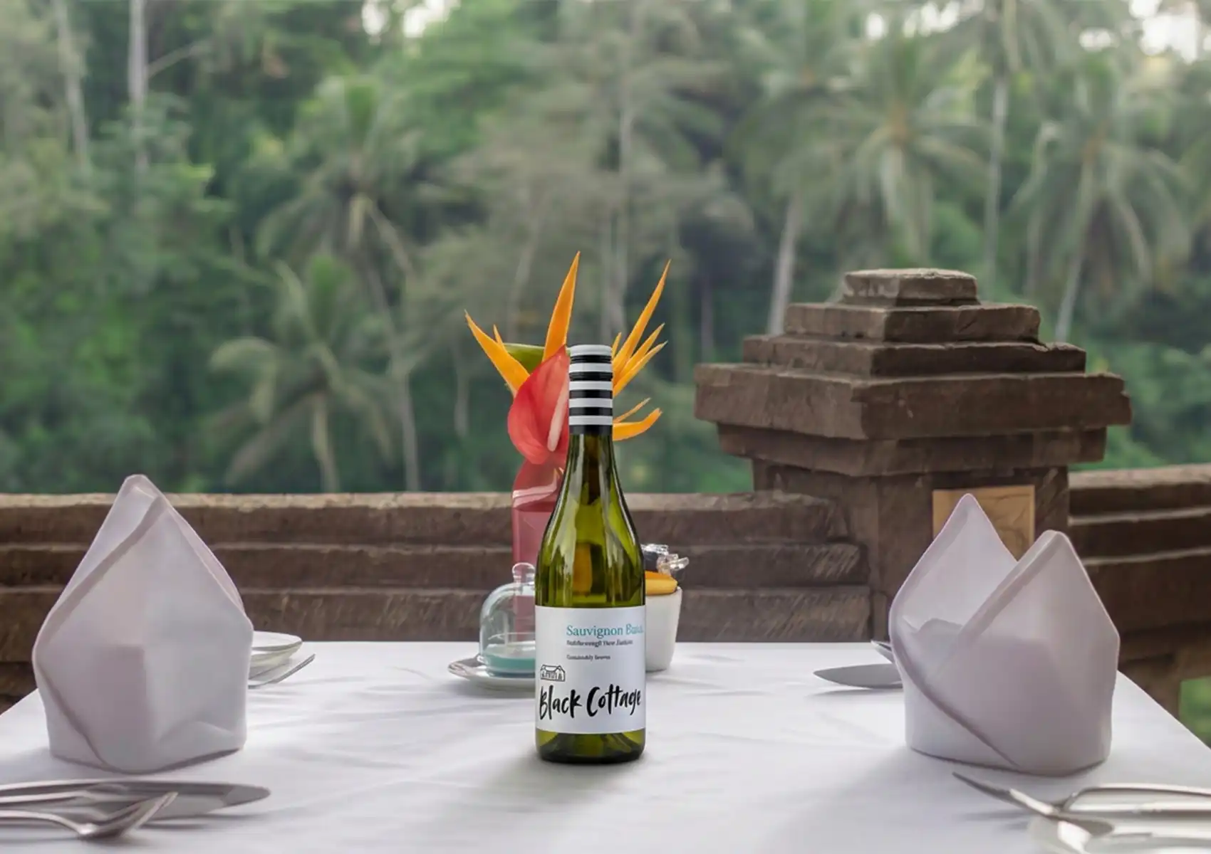Romantic outdoor restaurant in Ubud with tropical flower centerpiece and forest view."