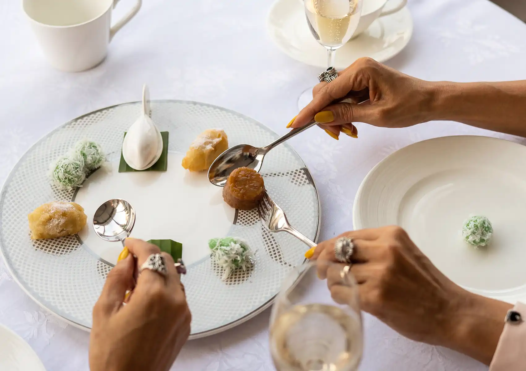 Elegant dining scene in Ubud with artisanal desserts on a white plate, served with champagne for a refined restaurant experience.