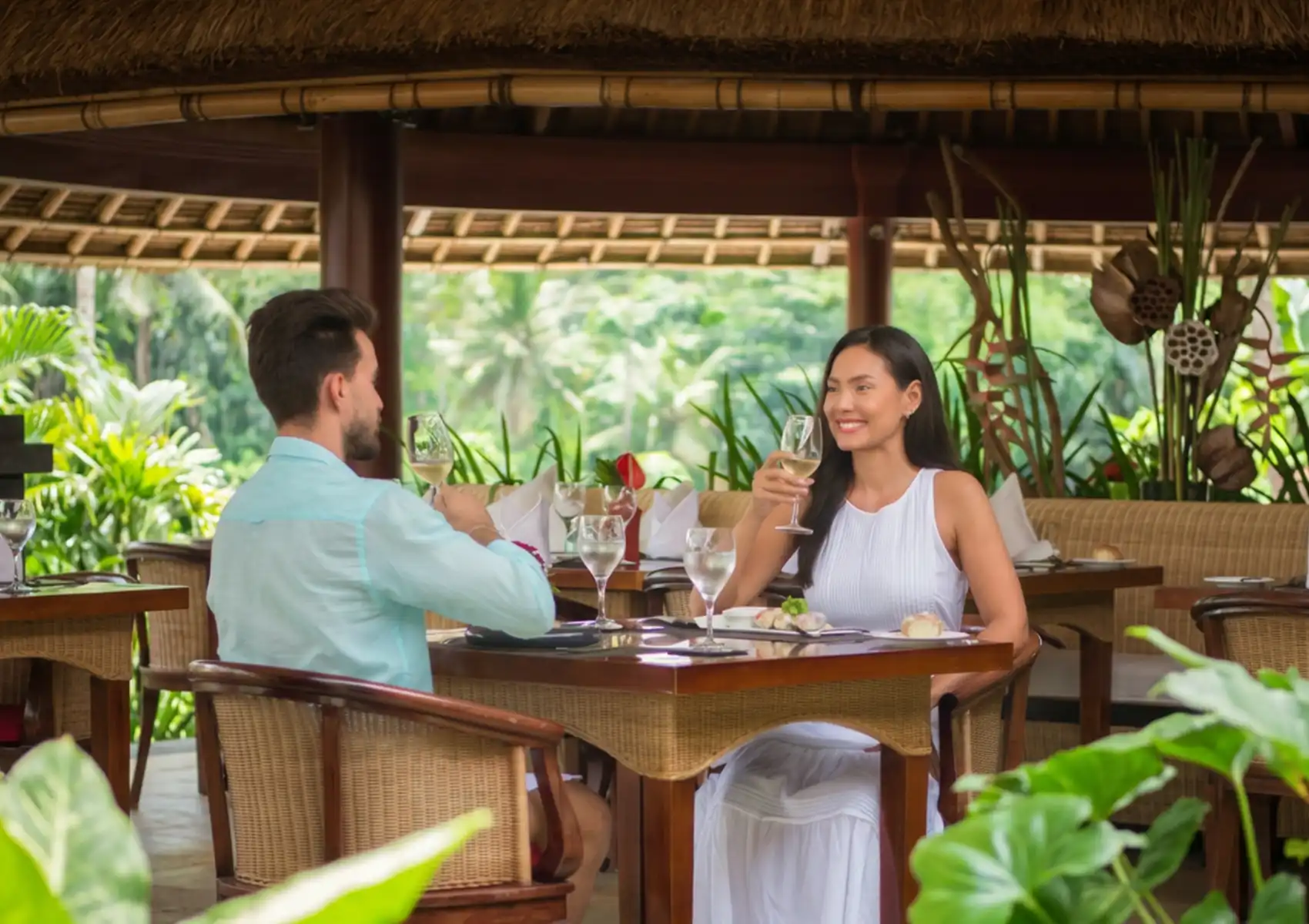 A couple enjoying wine and dinner at CasCades restaurant in Ubud, surrounded by tropical greenery and jungle views.